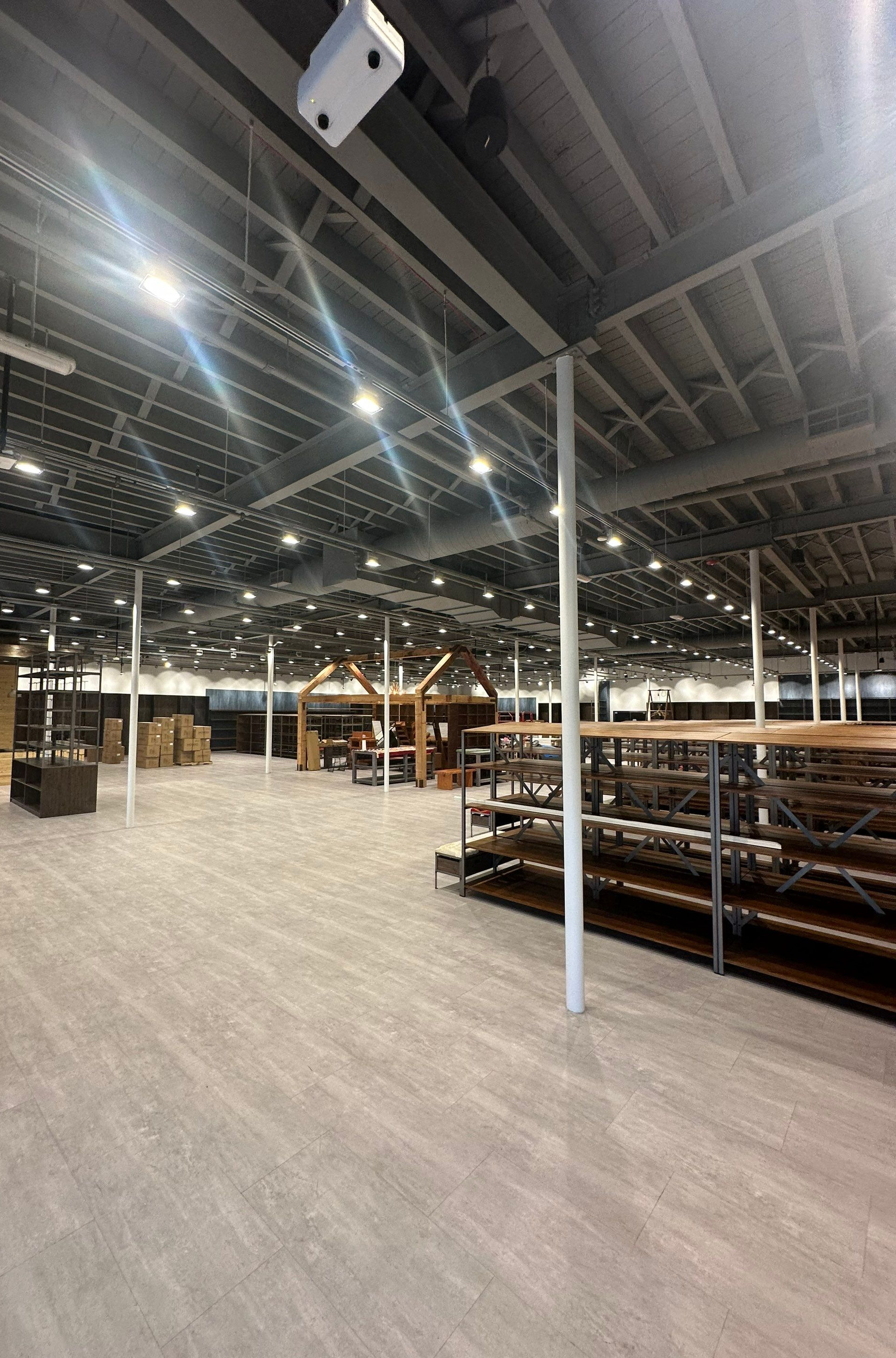 Boot Barn retail buildout in progress with custom wood slatwall, gondola shelving, and exposed ceiling systems